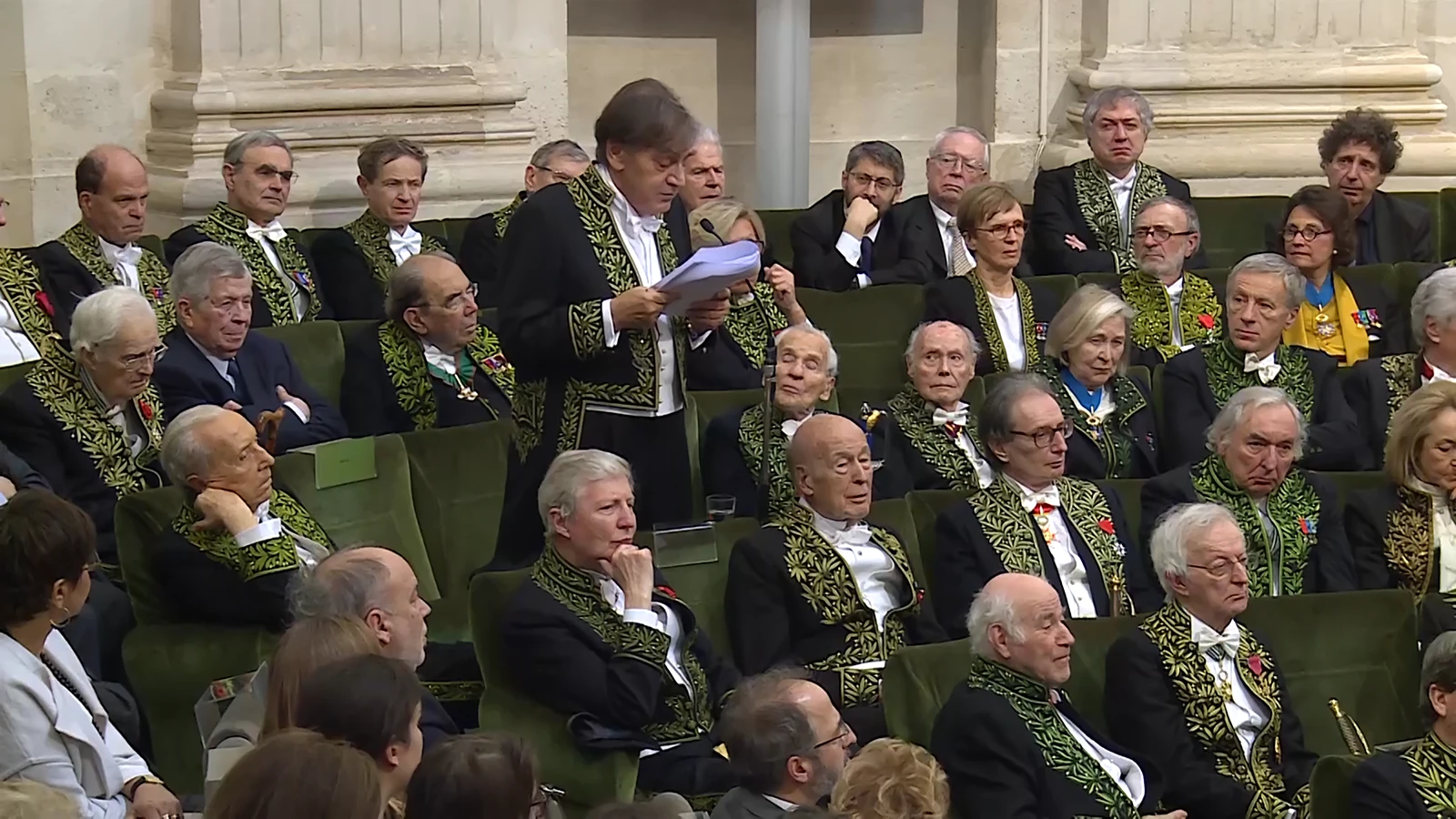 Ein Kandidat wird von der Académie française aufgenommen. Er darf fortan auf Fauteuil 21 Platz nehmen, neben 28 Männern und 6 Frauen (5 Fauteuils sind vakant). Bild: Screenshot der Aufzeichnung des Aufnahmezeremoniells.
